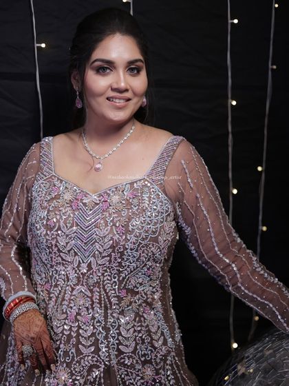 A portrait of a sangeet glam look. The makeup is soft yet defined, with a focus on flawless skin that glows under the party lights.