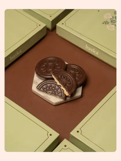 A creative shot of embossed chocolate coins for a Rakshabandhan collection. The geometric arrangement of the boxes creates a modern and visually interesting composition.