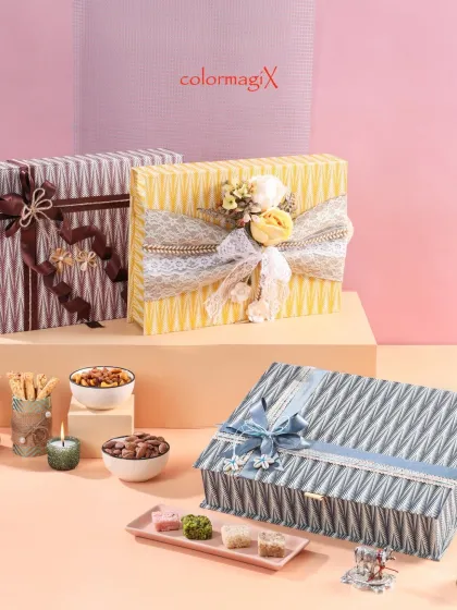 Three of our elegant striped boxes, each with a different colored ribbon, showcasing the versatility of this design for various themes and occasions.