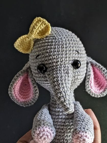 A close-up portrait of the elephant, focusing on her face and bow.