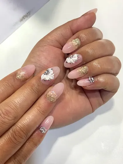 In my advanced nail art classes, I demonstrate the difference between various techniques. Here, you can see a comparison between gel and acrylic extensions, both featuring intricate 3D floral art and glitter accents, to help students understand the unique finish of each method.