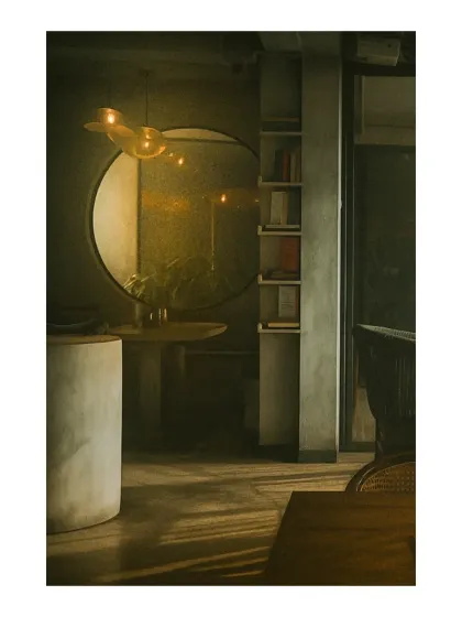 The play of light and shadow is a key design element. In this shot, you can see how the afternoon sun filters in, highlighting the textures of the raw concrete walls and the simple, elegant forms of the furniture.