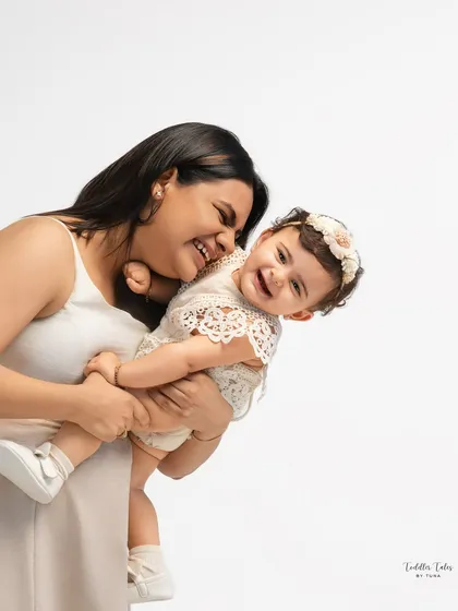 A candid moment of laughter and love between a mother and her baby. The clean white background ensures that your expressions and connection are the stars of the portrait.