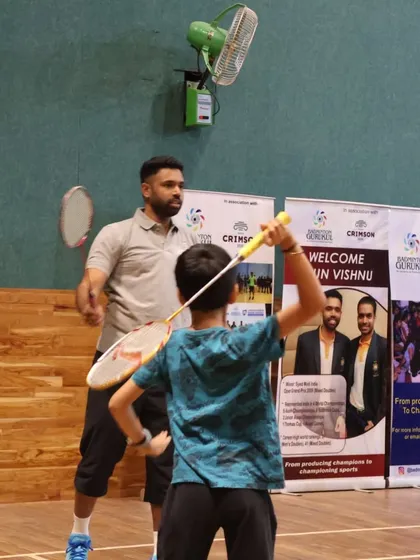 A young player receives personalized instruction on his swing technique from an expert panel coach.