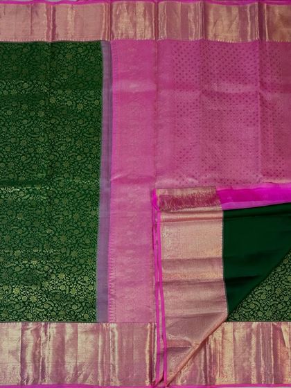 A view of the green brocade saree showing its rich pink pallu and blouse piece.