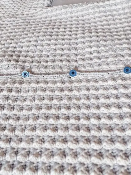 A close-up of the textured stitch and button details on the CoCo Jacket.