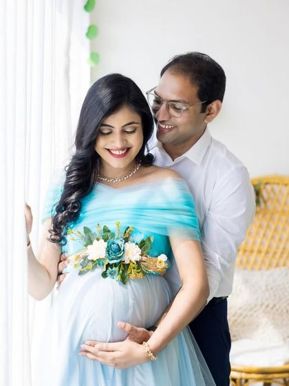 A happy couple shares a smile in a beautifully lit indoor studio. The light blue gown adds a touch of soft color and elegance to this cherished memory.