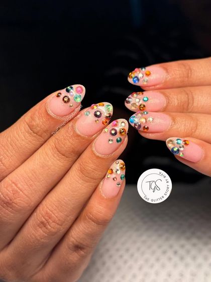 For the bride who loves a bit of sparkle. This design uses a neutral gel base as a canvas for a cascade of multi-colored rhinestones, creating a dazzling 'Navratan' inspired look.