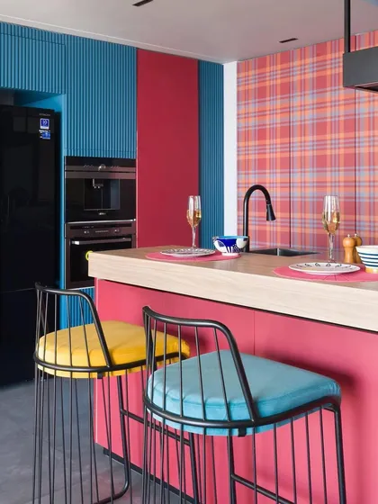 This kitchen is a masterclass in color and pattern mixing, with a vibrant combination of pink, blue, and red plaid. It's a perfect example of a maximalist, stylist kitchen.