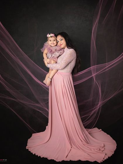 A mother and daughter in matching shades of pink. The flowing fabric adds a touch of elegance to this beautiful portrait.