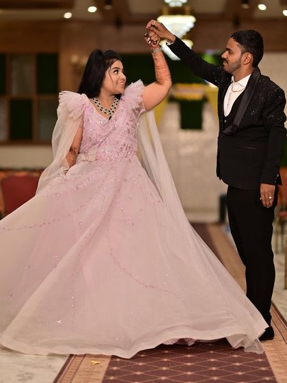 A dance to celebrate their engagement. The bride-to-be looks like she's floating in this light and airy pink gown with cape details.