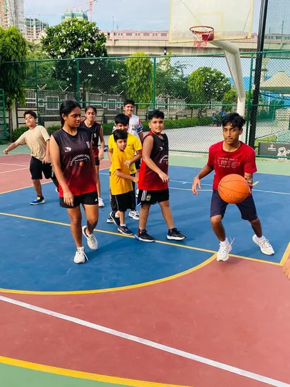 A coach provides instruction to a junior player on his dribbling form.
