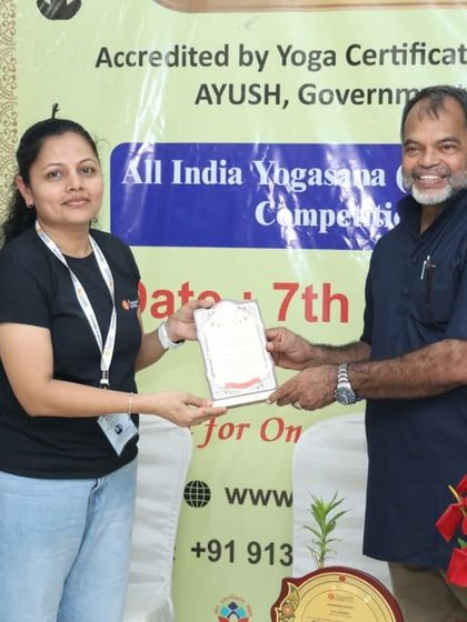 A moment of appreciation as one of our event anchors receives a certificate for her graceful and confident hosting of the Yogasana Competition.