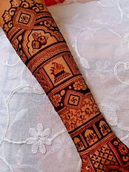 A single arm showing a band of traditional symbols, including a kalash and a sacred fire, perfect for wedding ceremonies.