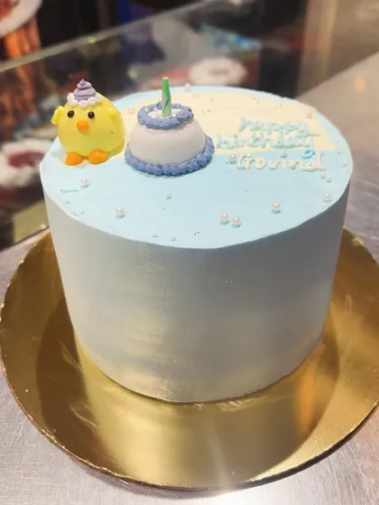 A simple and sweet light blue cake with adorable chick and mini-cake toppers.