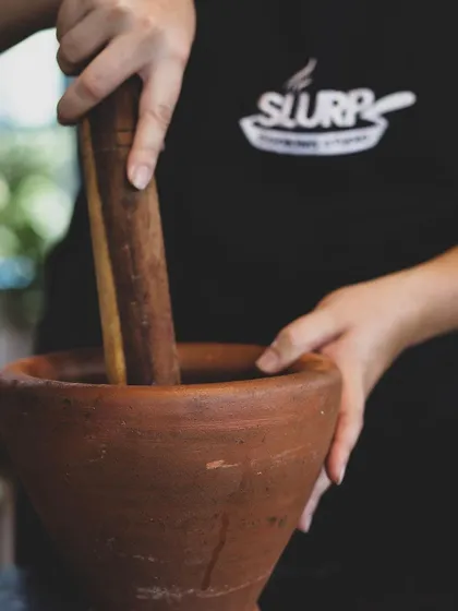 Using a traditional mortar and pestle to grind spices. We teach both modern and traditional techniques to give our students a well-rounded culinary education.