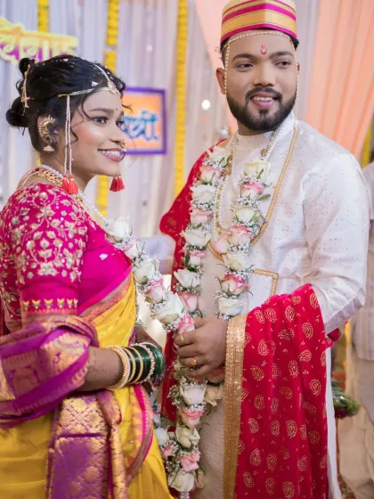 The couple stands together during the varmala (garland exchange) ceremony, a joyful and pivotal part of the wedding.