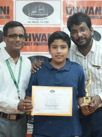 Instructors presenting an award to a student for his progress in drawing classes.