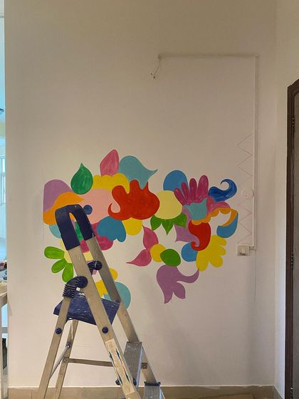 The beginning of a mural is like a blank page. For the 'Freedom Mural,' I started by blocking out the main color fields. This helps me map out the energy and movement of the piece before diving into the details.