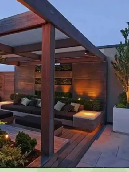Here is a perfect example of a modern rooftop lounge I created. The dark wood pergola, combined with built-in seating and warm, layered lighting, makes for an inviting space to entertain guests or relax with family after a long day.