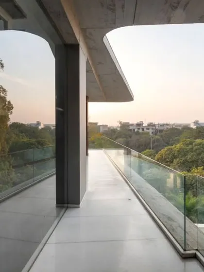 This elevated walkway is wrapped in glass, offering panoramic views of the surrounding greenery. It's a transitional space that allows you to feel connected to the outdoors even while moving through the home.