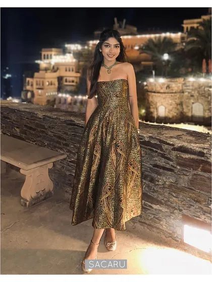 A client embodies pure elegance in her custom-designed strapless brocade dress at a destination event. The rich, paisley-patterned fabric and impeccable fit showcase our dedication to creating luxurious, memorable evening wear for any special occasion.