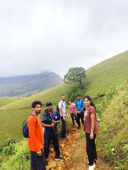 Our group hiking along a narrow path on the vast grasslands of Kudremukha. This shows the scale and beauty of the landscape.