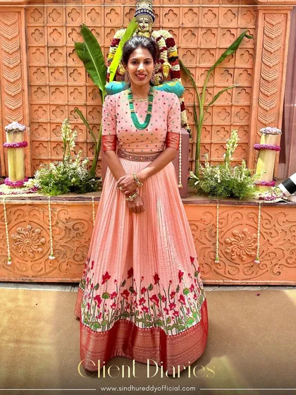 Our client looks radiant in a playful peach anarkali with lotus motifs, a perfect blend of tradition and modern style.