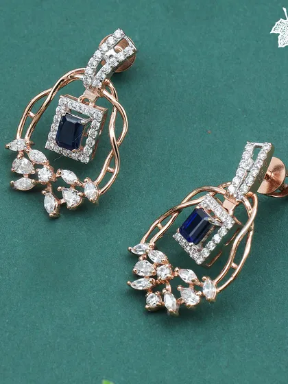 A close-up of the Sapphire Dream earrings. Each earring is a mirror of the pendant's design, capturing the deep blue of the sapphire and the brilliance of the surrounding diamonds.