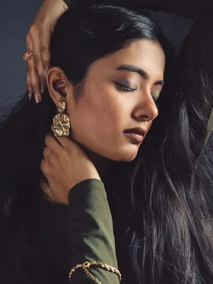 A moment of peace. This shot focuses on the elegant lines of the model's hands and face, highlighting the jewellery and serene expression.