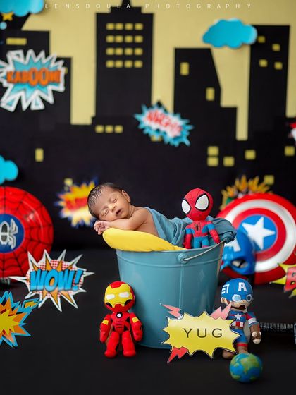 The full superhero setup, showcasing the cityscape background, "Wow!" and "Kaboom!" signs, and the team of heroes assembled around baby Yug.