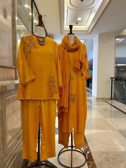 A full view of two yellow kurta sets, showcasing their comfortable silhouettes and cheerful color, ideal for festive occasions.