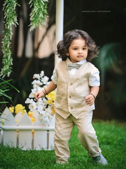 This little boy looks so dapper in his vest and bow tie during his outdoor session. His beautiful curly hair and thoughtful expression make for a stunning toddler portrait.