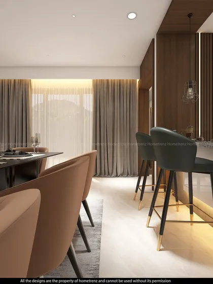 A view of the breakfast bar and dining area. The bar stools with gold-tipped legs add a touch of glamour, while the large windows provide ample natural light.