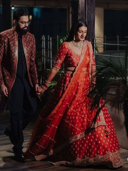 Our client, the groom, wears a richly detailed maroon and gold jacquard sherwani, perfectly complementing his bride. This is the epitome of royal wedding attire.