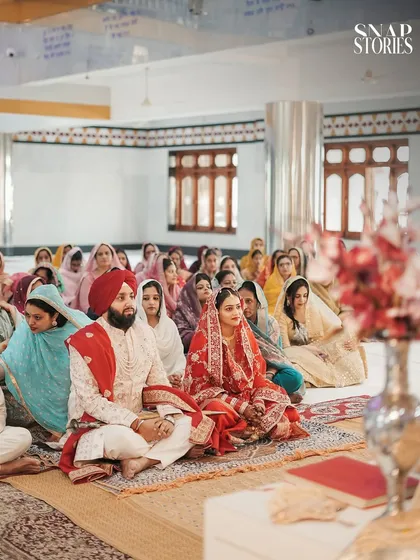 Another perspective of the Anand Karaj ceremony, showing the couple seated with their guests. We use different angles to provide a complete visual record of the event.