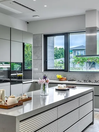 This handle-less kitchen in an Ahmedabad residence showcases contemporary luxury. The sleek, minimalist design in a custom RAL matt lacquer finish, combined with a spacious island, creates a space that is both highly functional and visually serene.