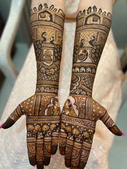 This bridal design features detailed portraits of the bride and groom on the palms. It's a classic way to personalize your wedding mehendi, surrounded by peacocks and elephants for good luck.