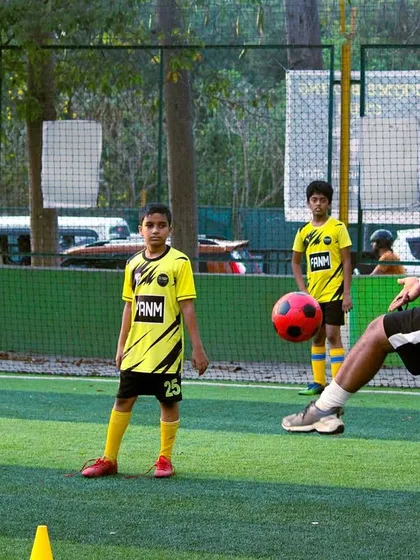 A coach demonstrates a passing technique, providing a clear visual example for the players to follow.