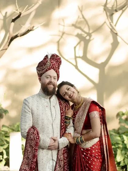 Finding comfort and peace in each other's arms. This relaxed portrait against a beautifully textured wall showcases a moment of quiet togetherness amidst the wedding festivities.