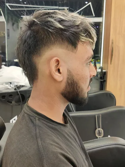 A side profile of a modern mullet with a sharp fade and highlighted, textured hair on top.