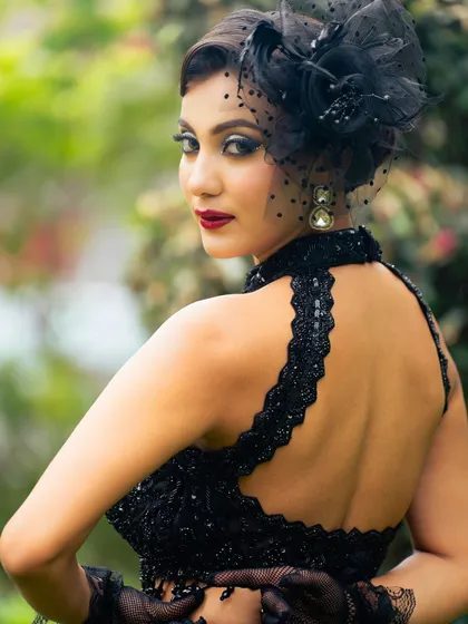 This shot captures the entire vibe of the look, from the dramatic makeup to the stylish black outfit and fascinator. It's all about creating a complete, cohesive story.