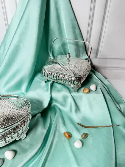 This square silver-plated basket with a hammered lid and ornate feet adds charm to any space. It makes an ideal choice for wedding giveaways or as a decorative storage box.
