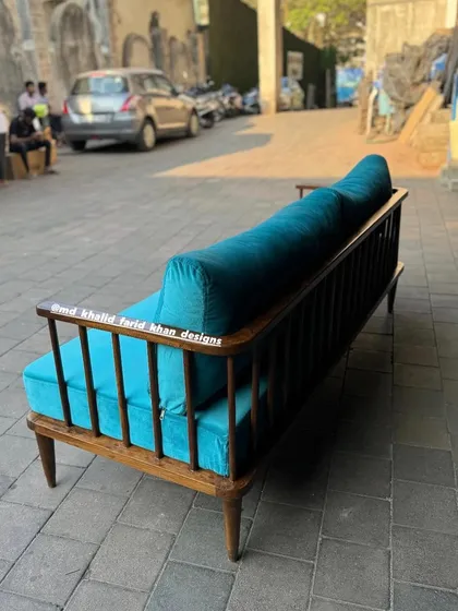 Another angle of the turquoise sofa, showing the elegant curve of the armrests.