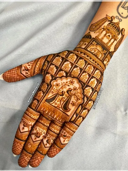 This intricate design features a central peacock motif surrounded by a dense grid pattern of lotuses and elephants, with a palace scene on the wrist.