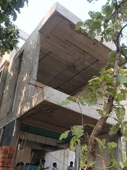 A low-angle shot of the villa's concrete shell during construction. You can see the jutting-out deck and double-height spaces taking shape, which are key features of the design.