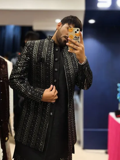 A mirror selfie capturing the detailed embroidery and fit of our black and silver Indo-western jacket.