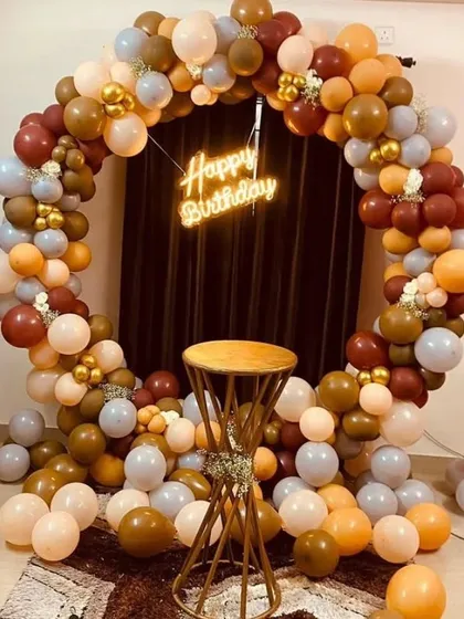 An earthy-toned balloon ring in shades of brown, orange, and grey with a neon sign.