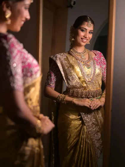 A bride's happy reflection. This shot captures the joy of seeing the complete South Indian bridal look come together, from the flawless makeup to the perfectly draped saree.