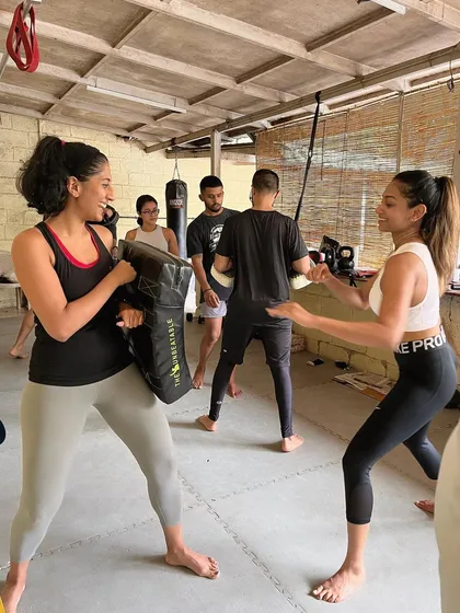 Two members smiling while they work through a partner drill.